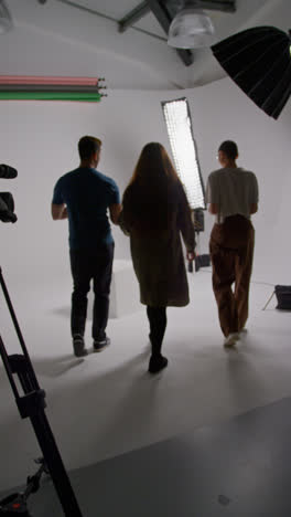 Vertical-Video-Of-Film-Director-Talking-With-Male-And-Female-Actors-Holding-Scripts-Rehearsing-For-Shooting-Movie-Or-Video-In-Studio-3